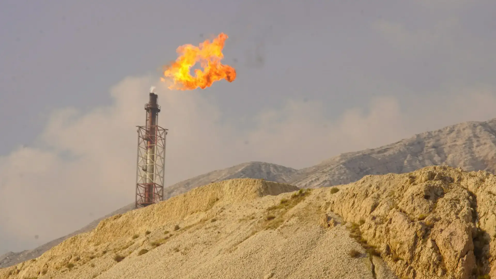 Antorcha de gas natural iluminando el cielo nocturno en un campo de explotación boliviano